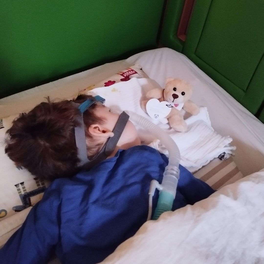 Emil in seinem Bett mit einem Sauerstoffgerät